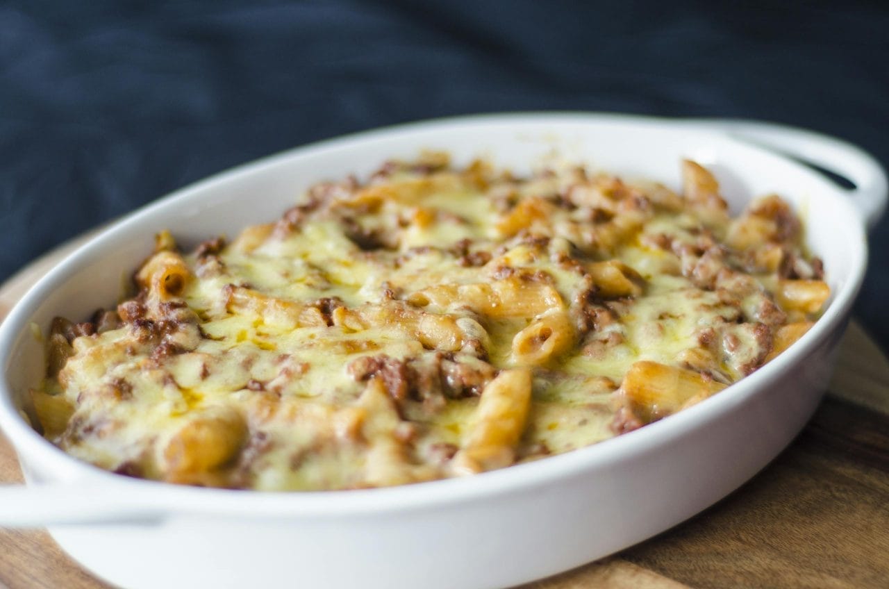 Close-up of a homemade baked macaroni and cheese in a white dish. Perfect comfort food for lunch or dinner.