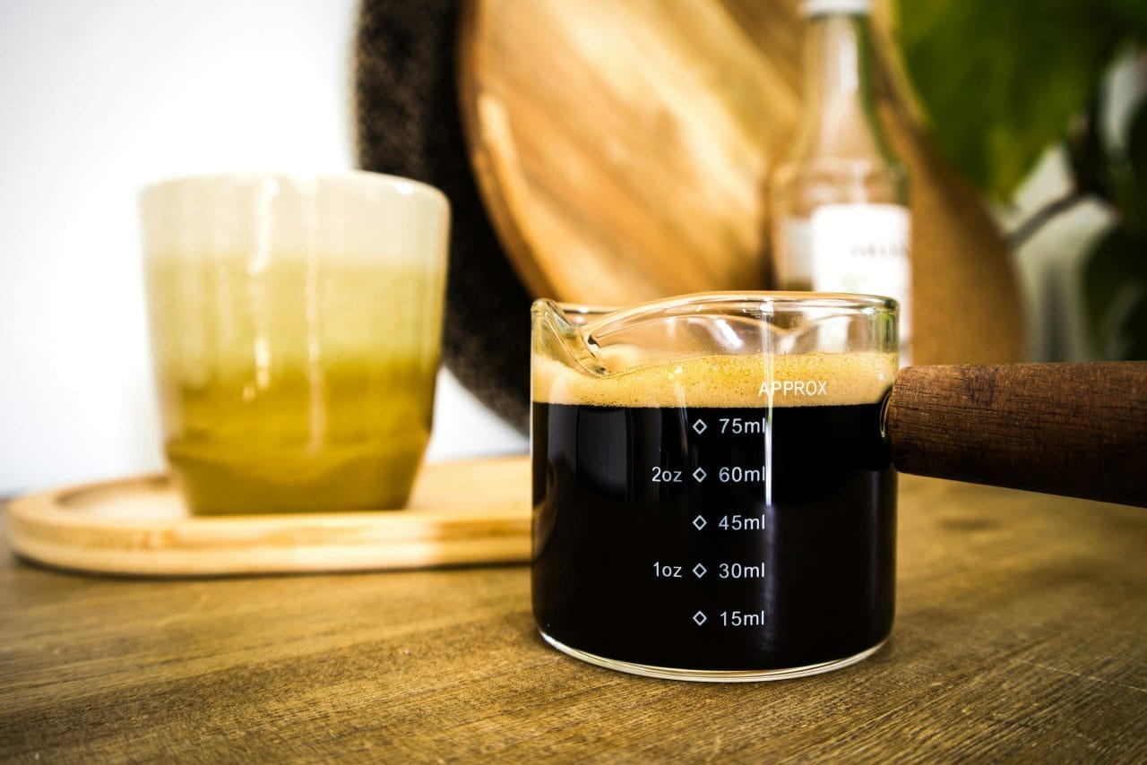 Close-up of espresso in a measuring cup with crema, ideal for coffee enthusiasts.
